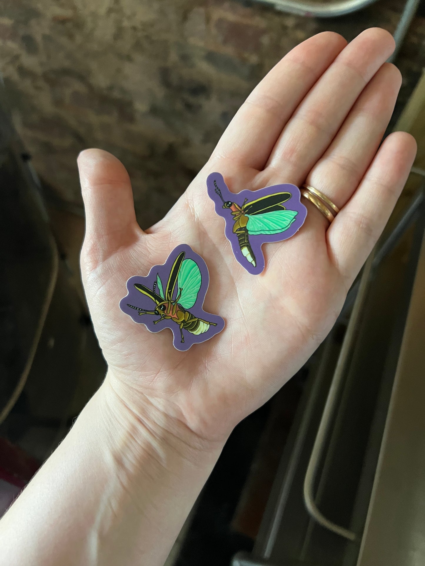 two firefly stickers made of glow in the dark material, indoors.